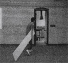 Кадр из триады (человек тащит доску в комнату